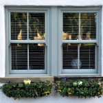 home with sliding sash windows and plants in window boxes